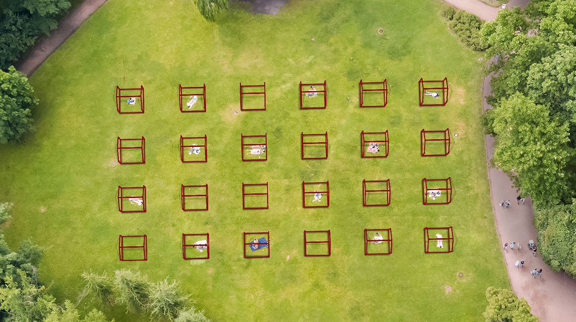 People sunbathe on a green lawn in a summer park, top view